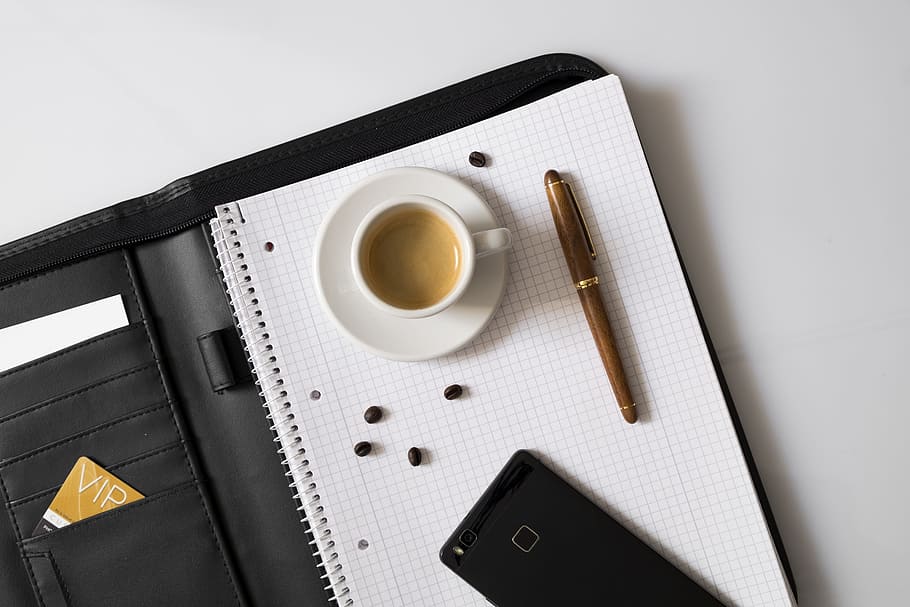 flat lay photography of cup of coffee, graphing paper, pen, and smartphone on black leather flip case HD wallpaper