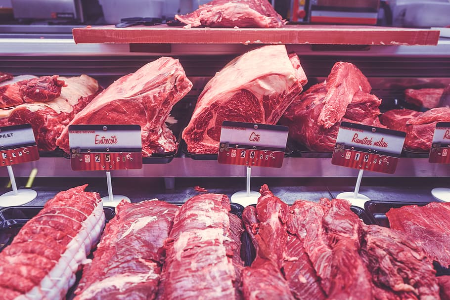 slices of meat in commercial freezer, bunch of raw meats on display counter