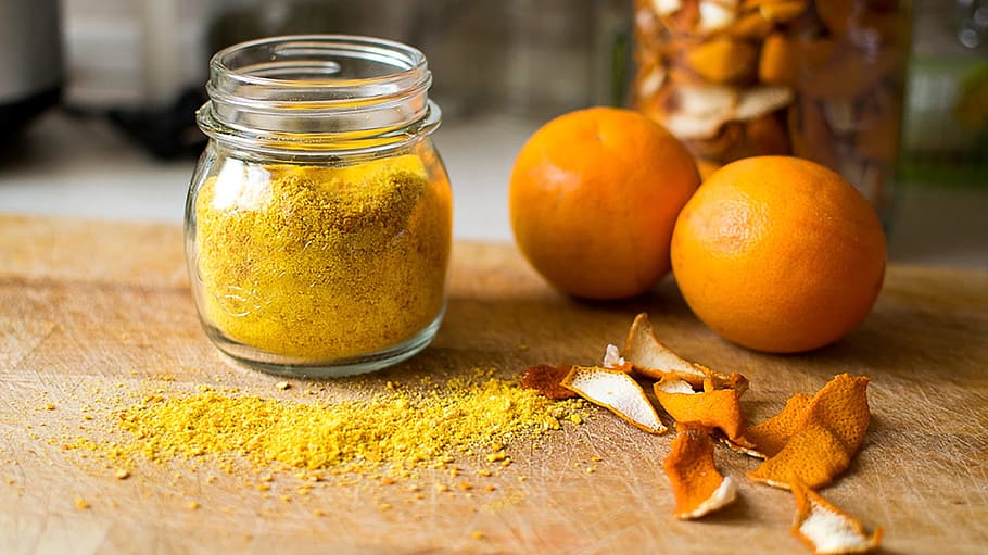 brown powder in glass jar beside two orange fruits, dust, drying HD wallpaper