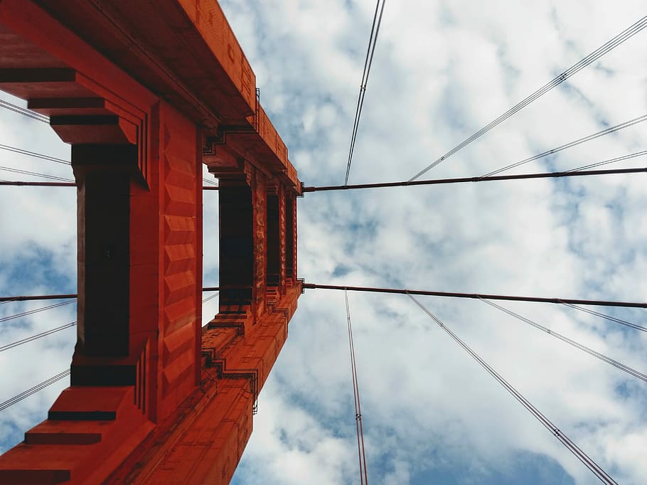 low angle photo of Oakland Bay Bridge tower, brown concrete structure under blue sky HD wallpaper