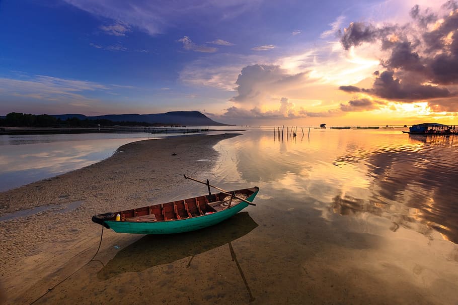 green and brown boat on seashore during golden hour, sunset, the boat
