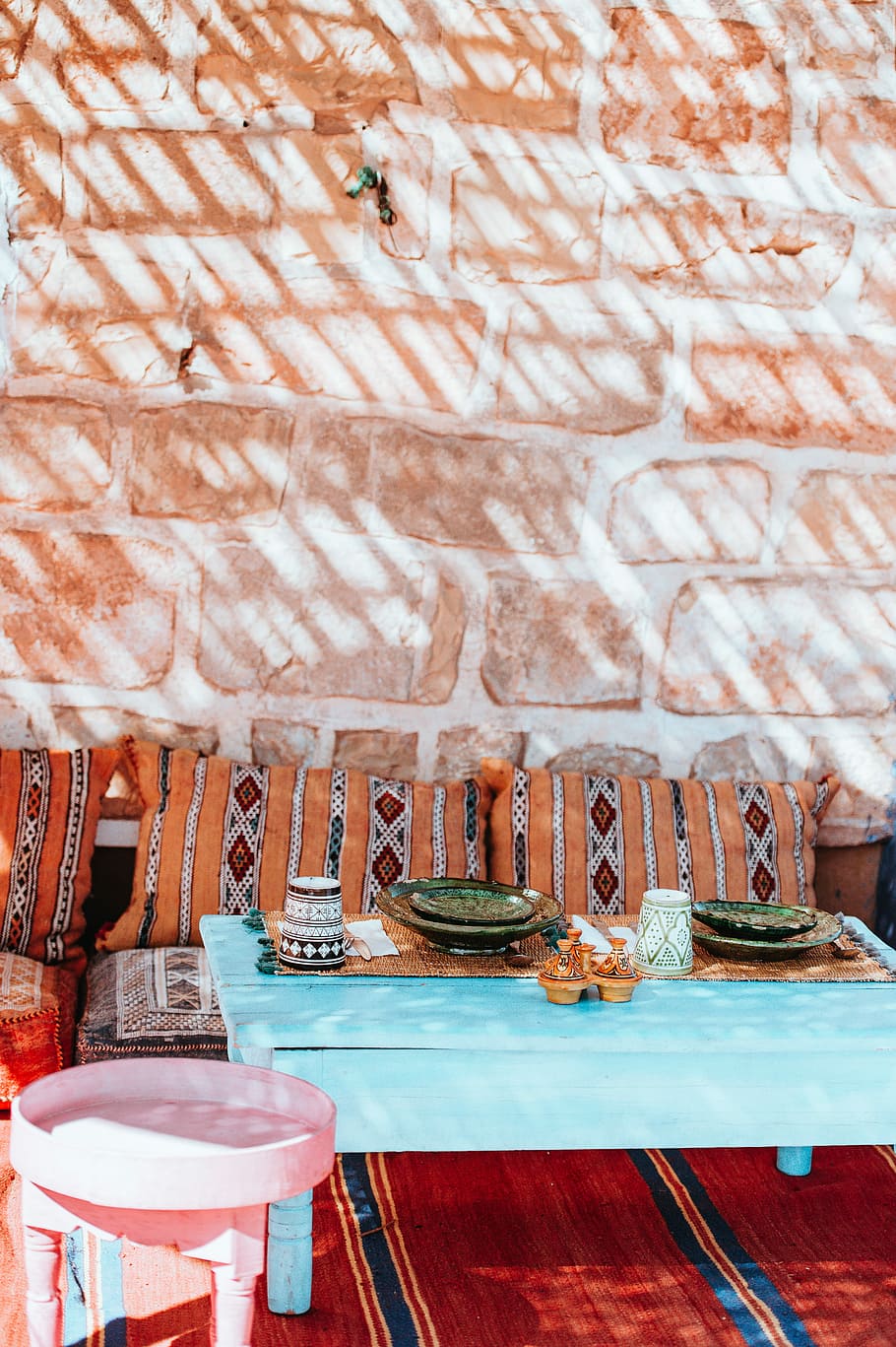 Moroccan Dining, plates on teal coffee table, brick wall, bench HD wallpaper