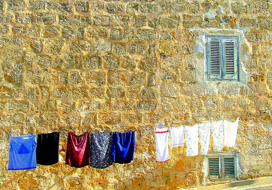 assorted clothes hanging on gray string during daytime photo