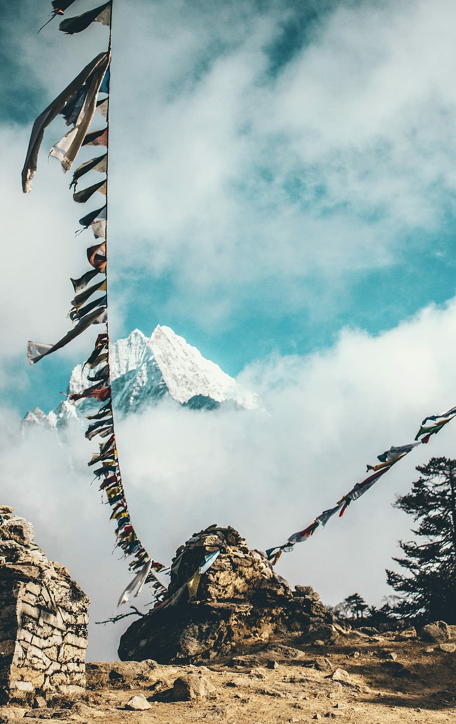 two clothes line attached to stone near snow capped mountain at daytime, gray rock formation with pennant HD wallpaper