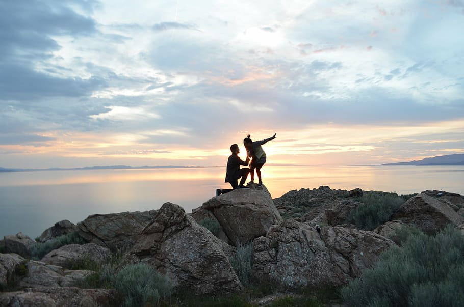 silhouette of man and woman on top of rock formation, engagement HD wallpaper