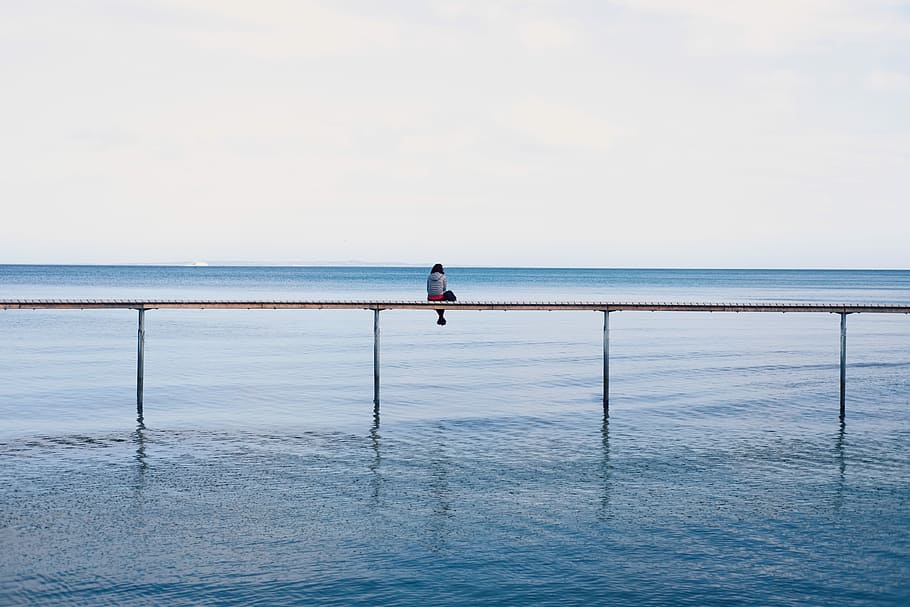 person sitting down on frame, person in dock during daytime, water HD wallpaper