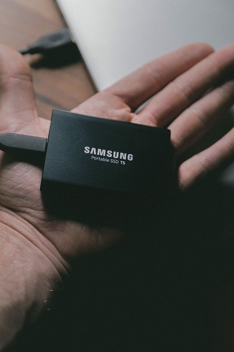 Samsung portable T5 SSD on person's hand, person holding Samsung Portable SSD TS adapter