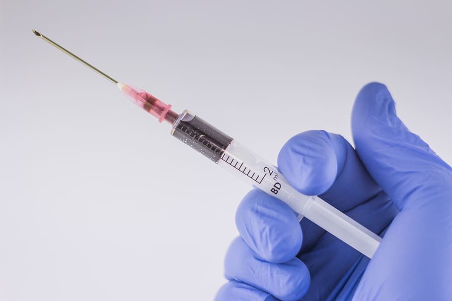 person carrying white syrinfge, needle, the syringe, blood, hospital