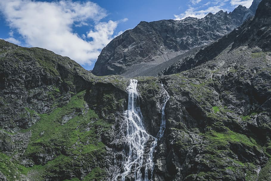 waterfalls near mountains during daytime, mountain with waterfall under blue sky HD wallpaper