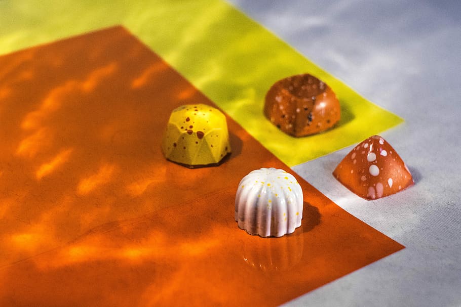 four assorted-shape chocolates, four chocolate candies on surface HD wallpaper