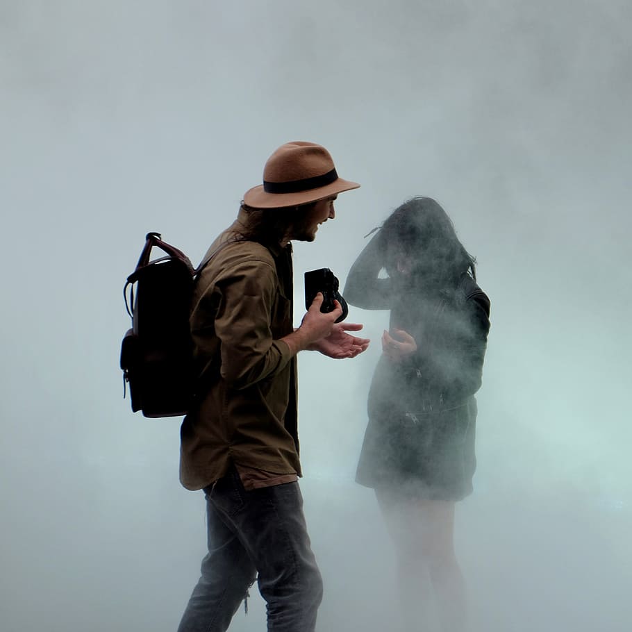 man holding camera in front of girl, man standing while holding black camera in front of woman in black dress, HD wallpaper