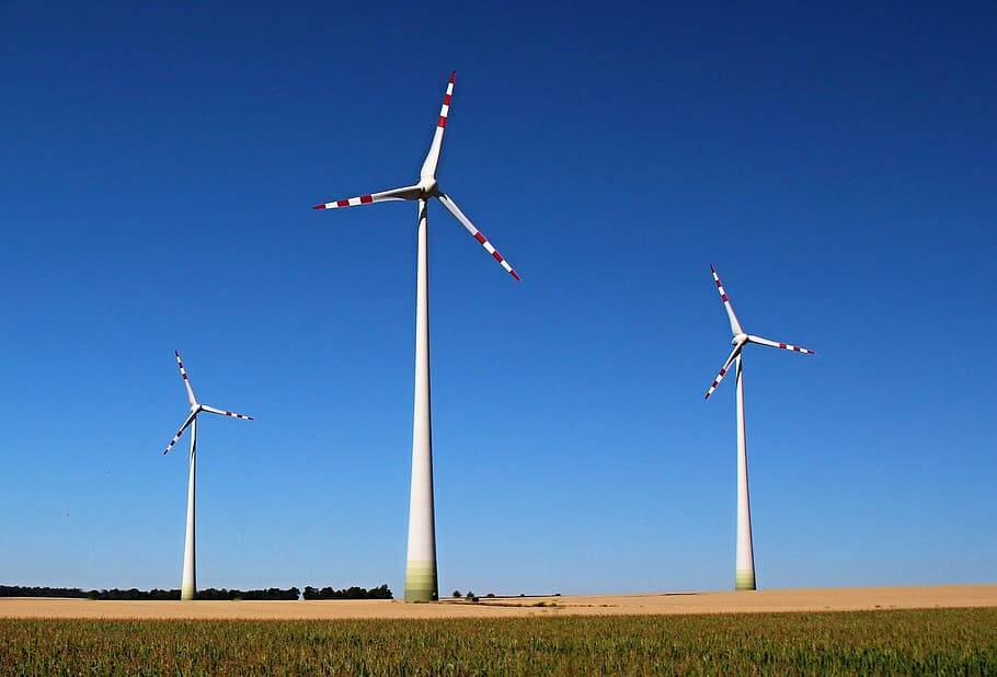 worm's-eye view of windmills under blue sky, wind energy, renewable enegy