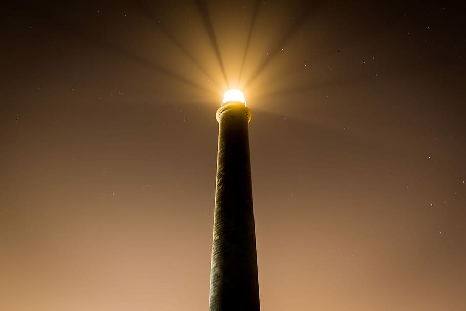 powered on lighthouse, turned on light above brown architecture HD wallpaper