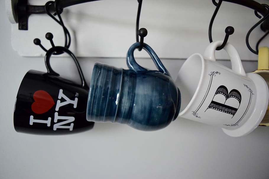 three hanged assorted-color ceramic mugs, three blue, black, and white ceramic mugs HD wallpaper