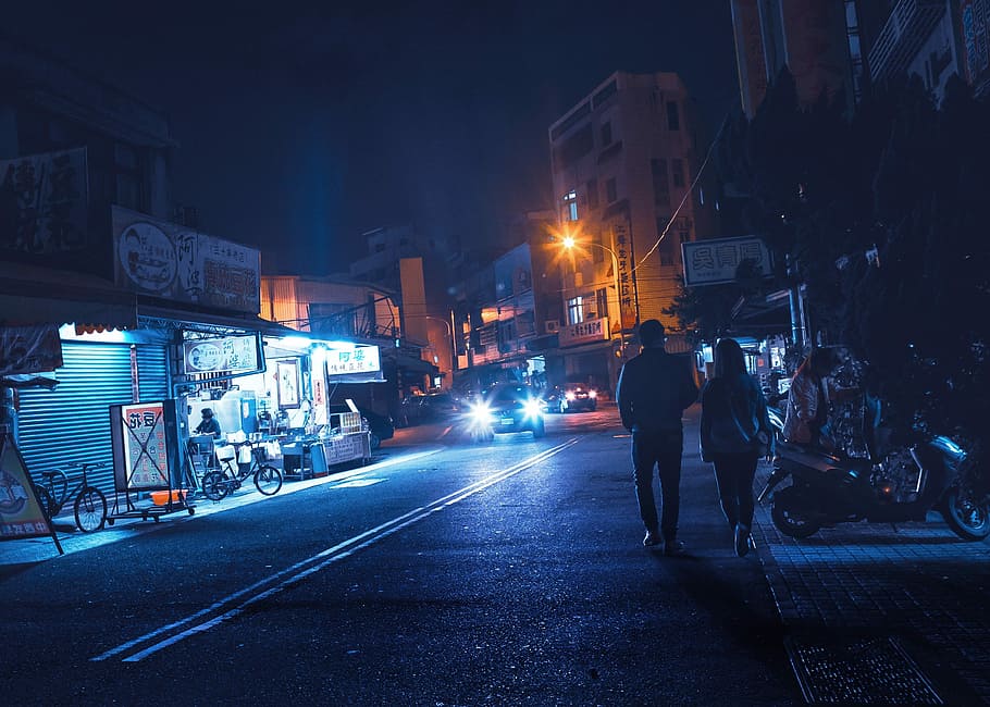 City at night, man and woman walking on road, street, couple