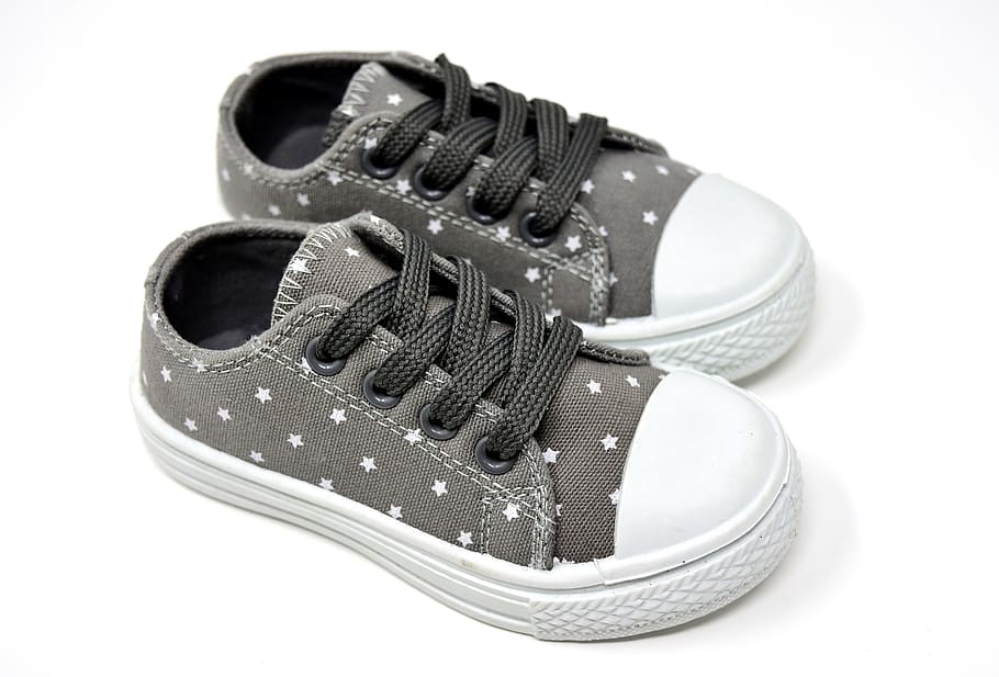 pair of girl's gray-and-white low-top sneakers on white surface