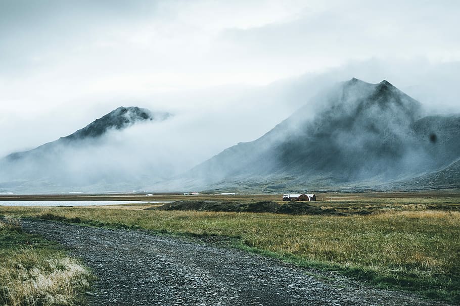 mountain covered with fogs, green grassland in front of two mountains HD wallpaper