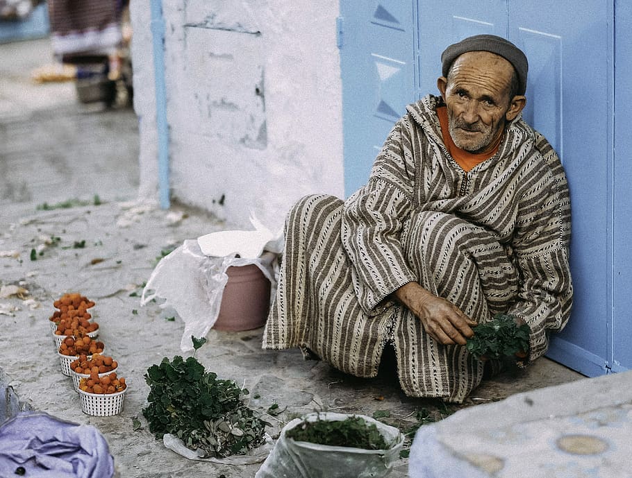 man selling green leaf vegetable, man holding green plant white leaning on wall HD wallpaper