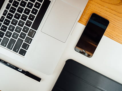 space gray iPhone 5s near MacBook Pro on brown wooden surface HD wallpaper