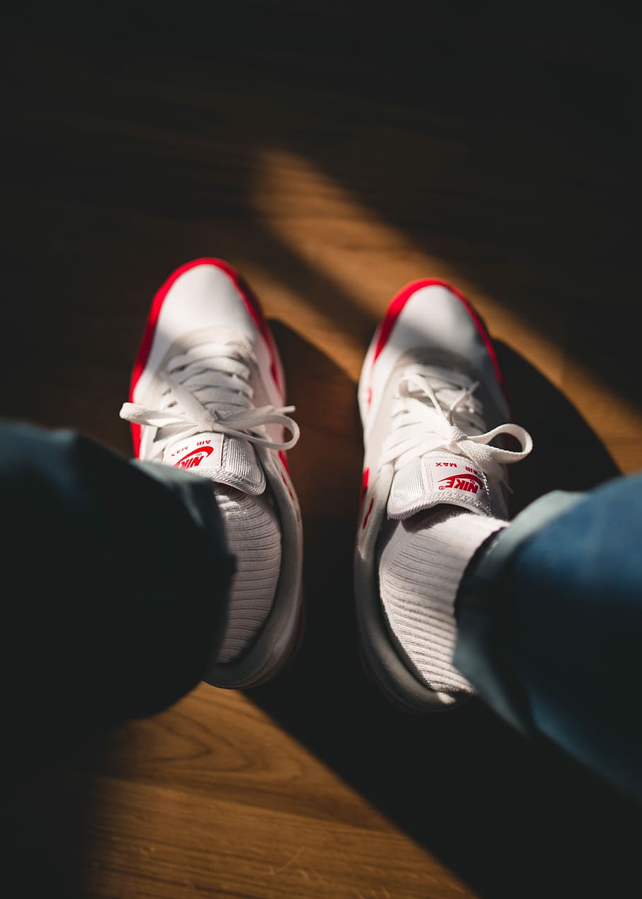 person holding white-and-red Nike running shoes, pair of white-and-red Nike low-top sneakers HD wallpaper