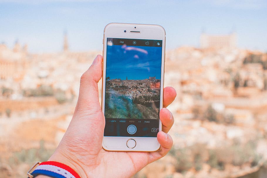 person holding gold iPhone 6 during daytime, person taking a photo of a landmark HD wallpaper