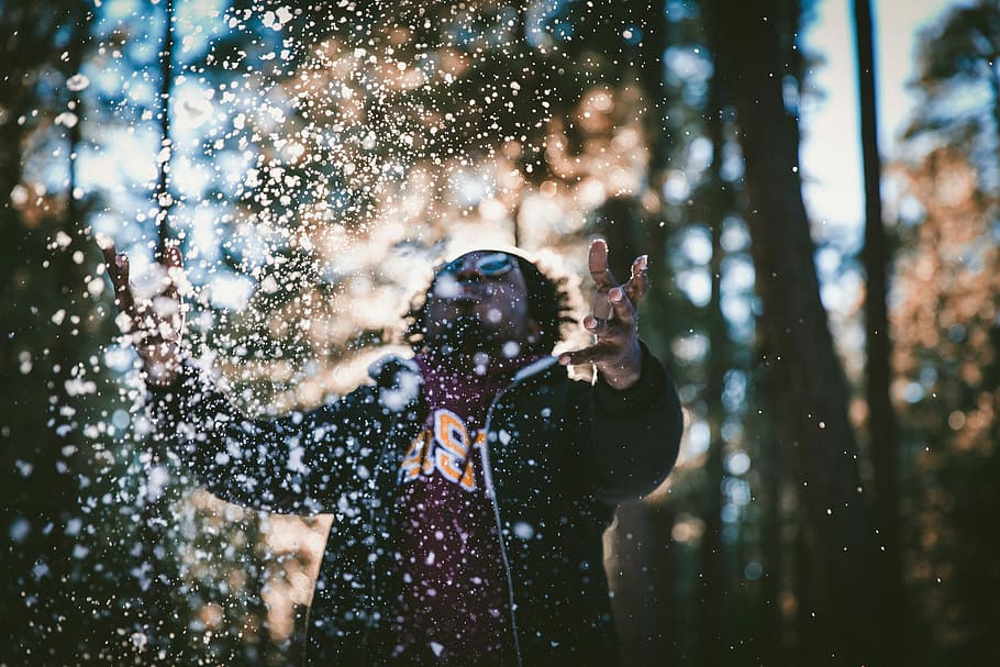 man playing water drops during daytime, man wearing jacket macro photograhpy HD wallpaper