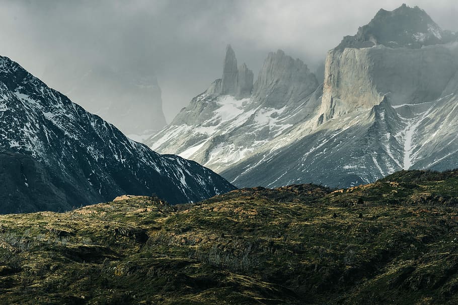 green hills near gray mountains, mountains with fogs during daytime HD wallpaper