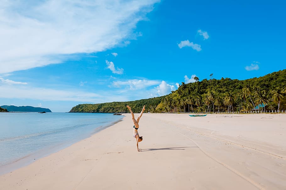woman standing on hands on beach, sea, ocean, water, waves, nature