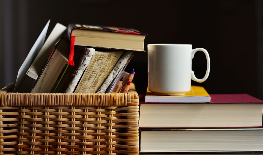 white ceramic mug beside books in brown wicker basket, learn HD wallpaper
