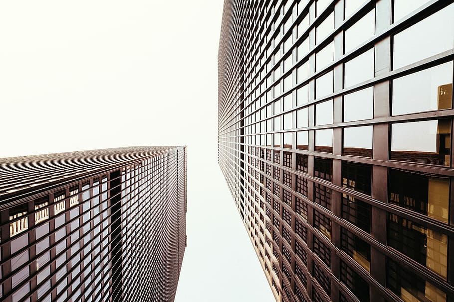 low angle photo of highrise building during daytime, low-angle sepia photo of two buildings HD wallpaper