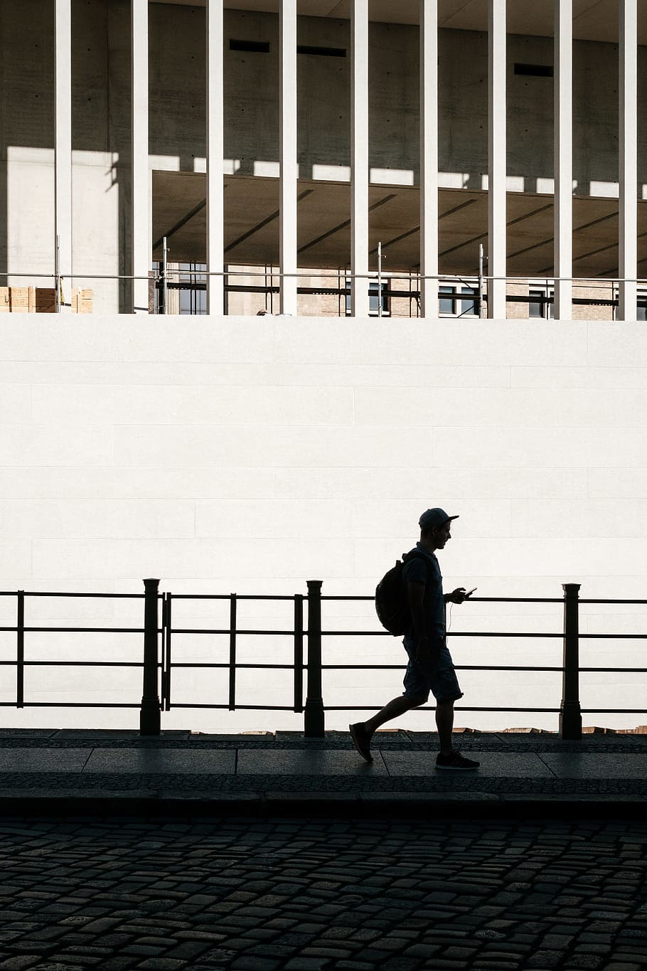 silhouette of man standing beside road rail, silhouette of walking man along sidewalk HD wallpaper