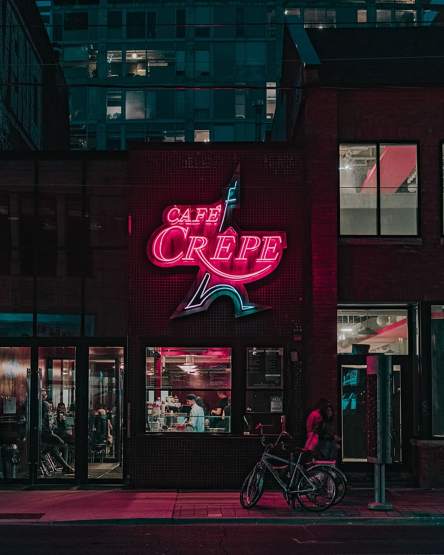 two people standing in front of Cafe Crepe storefront, Cafe Crepe signage