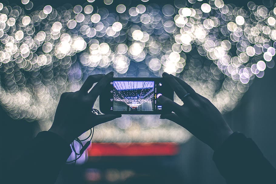 selective focus photography of person holding smartphone while taking picture of scenery, person getting a picture to an event HD wallpaper