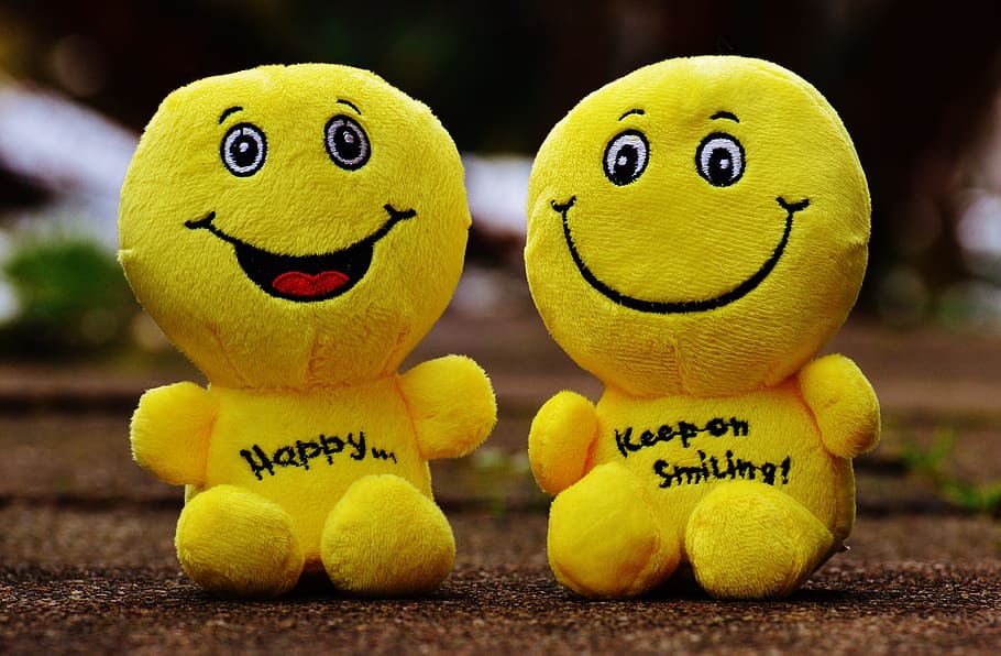 two emoji plush toys on brown surface, smiley, laugh, funny, emoticon