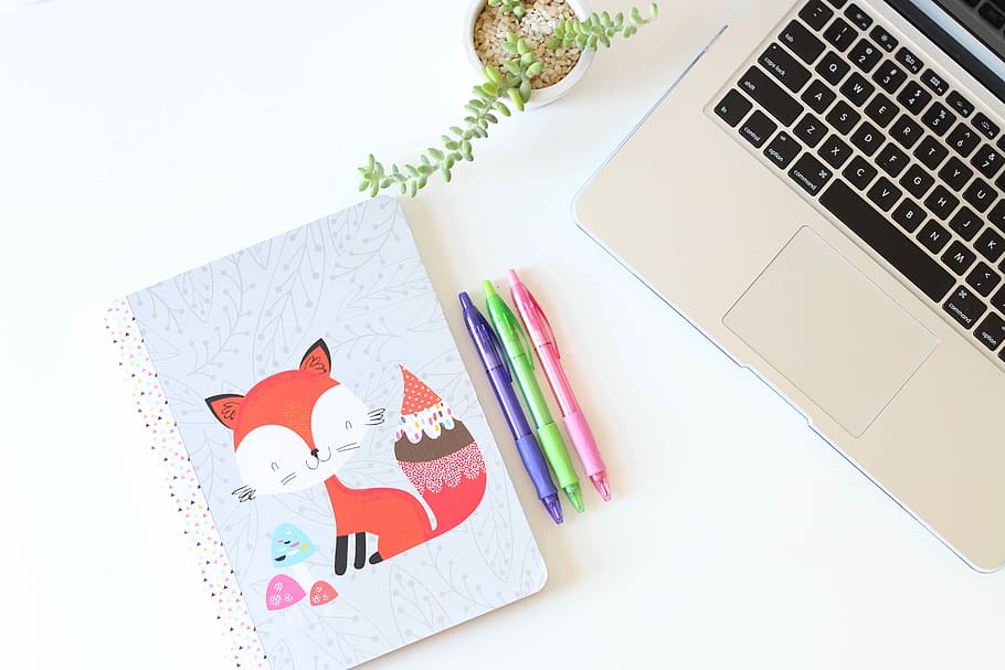 three assorted-color click pens between notebook and MacBook, three assorted-color click pens beside grey laptop HD wallpaper