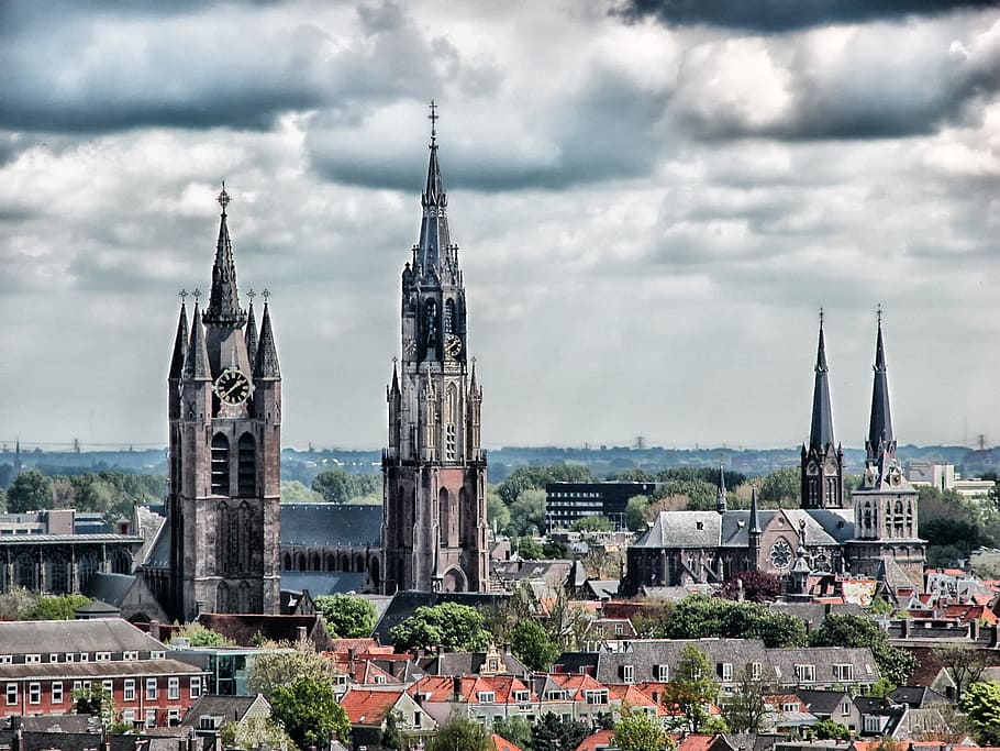 black and brown concrete cathedral under cloudy sky, delft, netherlands