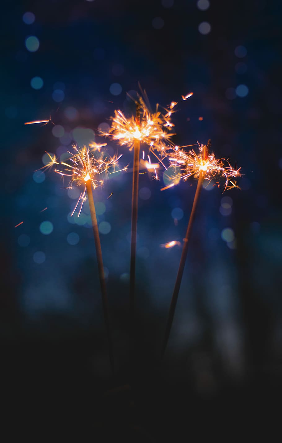 three sparkler sticks, photo of three sparklers, firework, dark