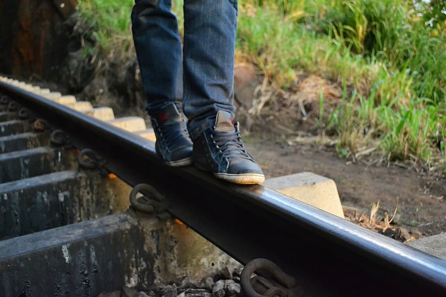 photo of person standing on railway, feet, shoes, legs, jeans