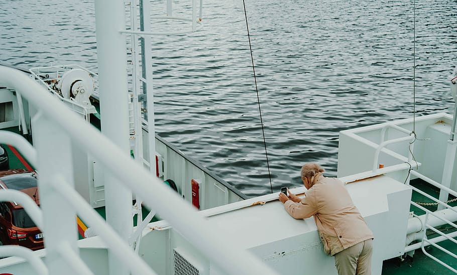 man wearing brown blazer standing on the ship, man at ship during daytime HD wallpaper