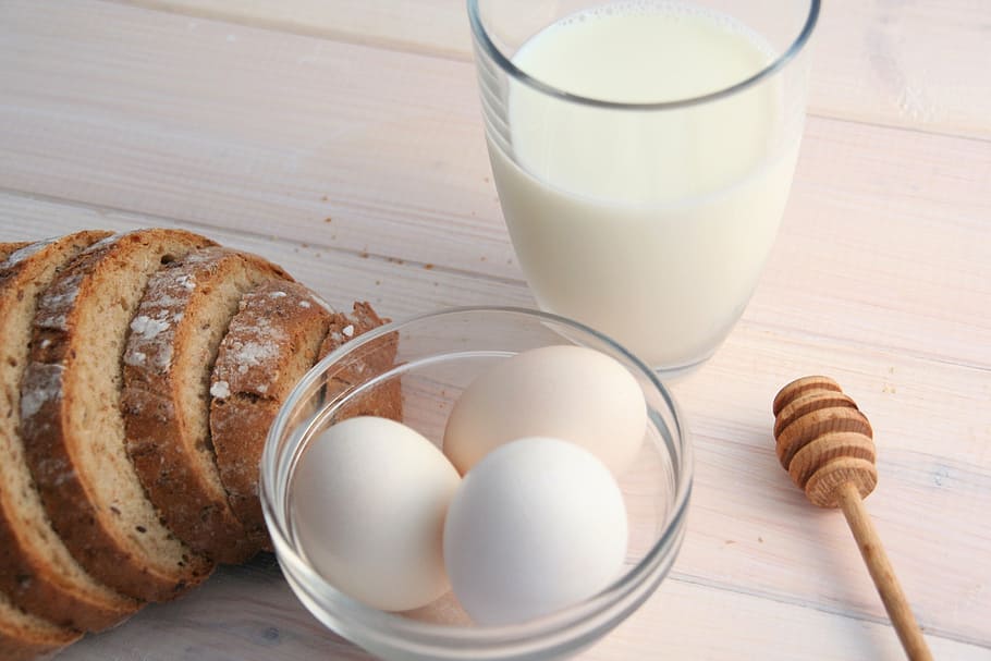 three white eggs in clear glass bowl surrounded by breads and milk in drinking glass HD wallpaper