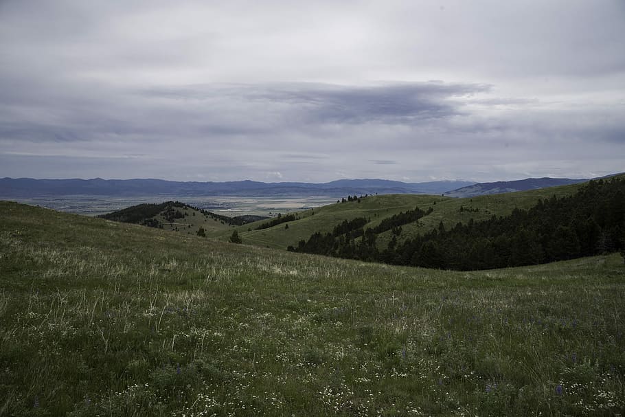 Overlapping hill landscape with mountains in the background in Helena HD wallpaper