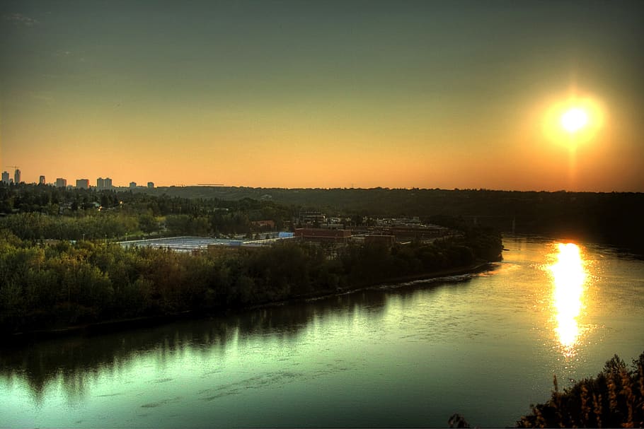 top view of body of water beside green trees during sunset HD wallpaper