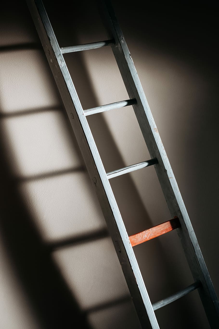 An old wooden ladder casting soft shadows on wall, white step ladder lean on wall with shadow, HD wallpaper