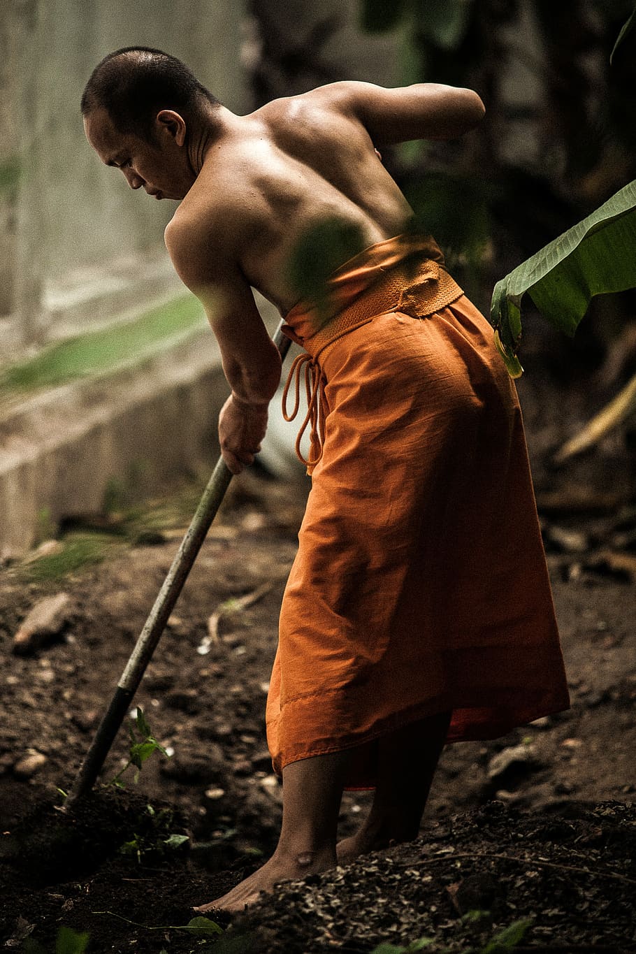 monk gardening near grey wall, man shoveling soil, work, labour HD wallpaper