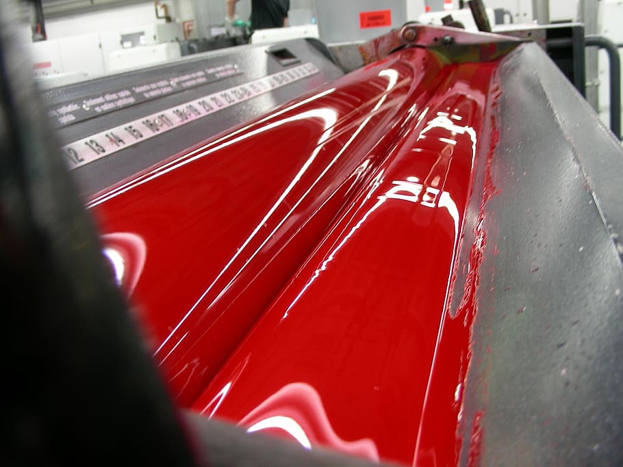 close up photo of red liquid flowing on gray metal surface, color