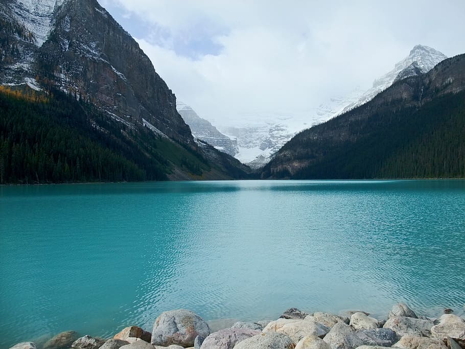 calm body of water between mountain alps, lake louise, canada