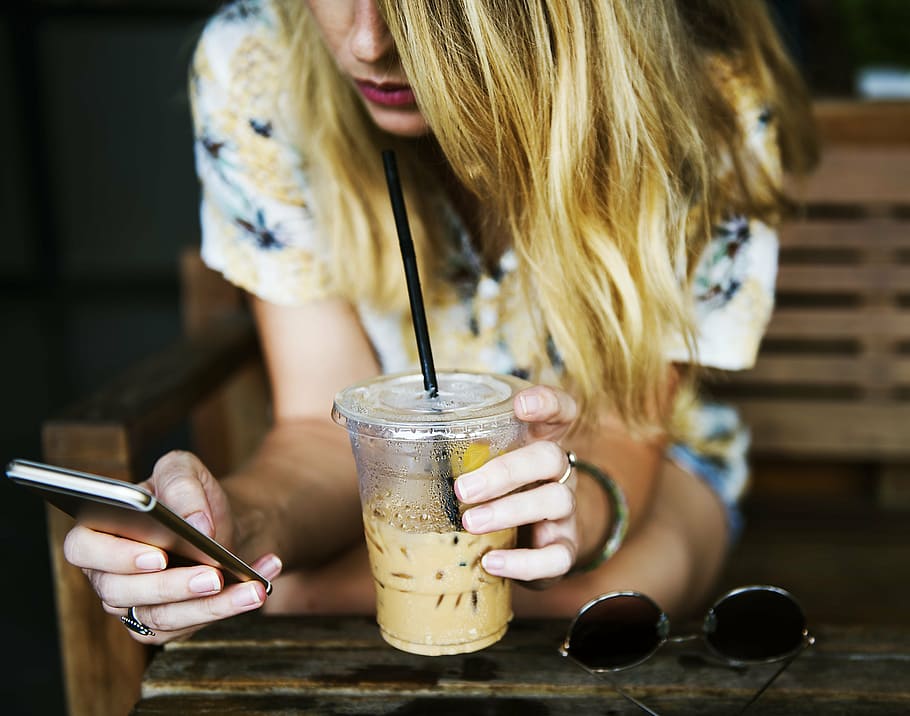 selective focus photography of blonde haired woman sipping yellow liquid while using smartphone, HD wallpaper