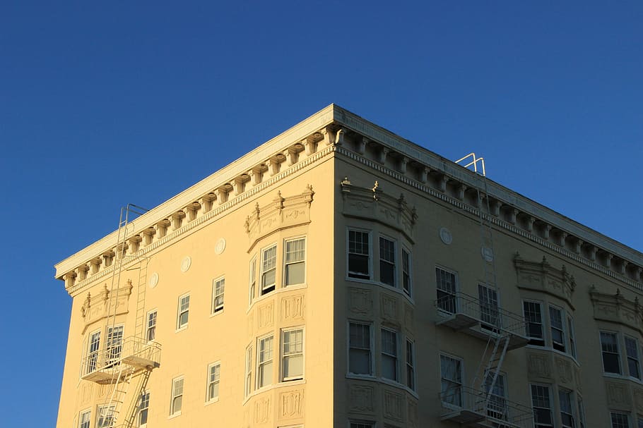 beige concrete building under blue sky, yellow concrete building