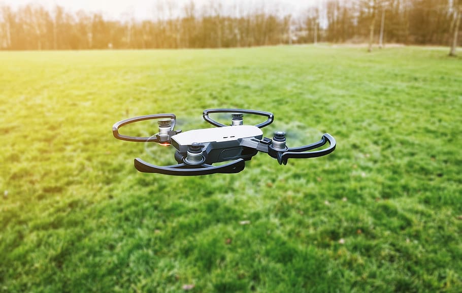 black quadcopter drone on open field, black and gray quadcopter drone flying above ground at daytime HD wallpaper