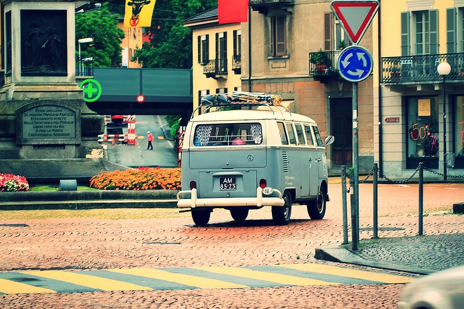 white and blue Volkswagen T2 on road in front of beige concrete 2-storey house